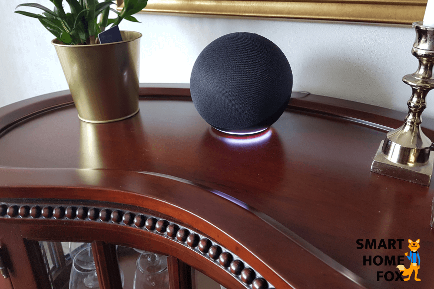 Amazon Alexa Echo steht auf dem Tisch und leuchtet weiss 